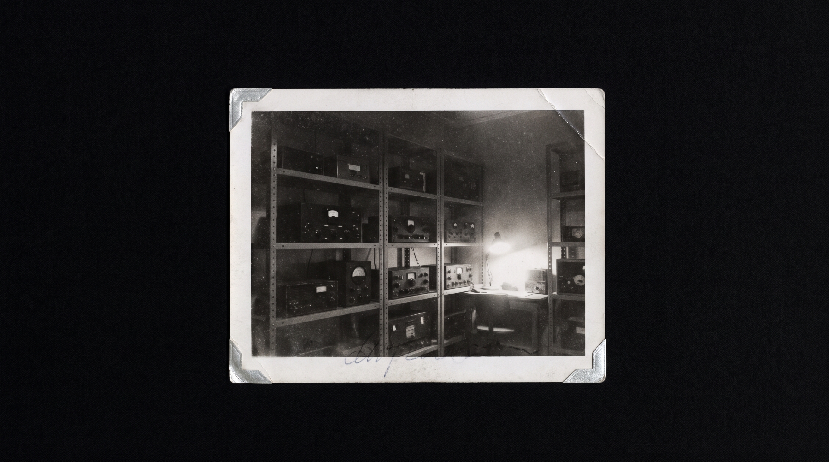 A black-and-white photograph of a receiver room shelving unit, cataloguing tags hanging from unlabeled reels.
